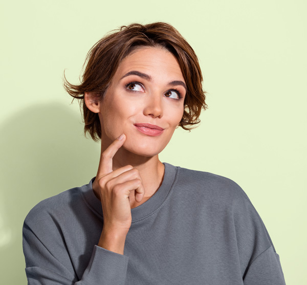 Junge Frau schaut nachdenklich hoch.