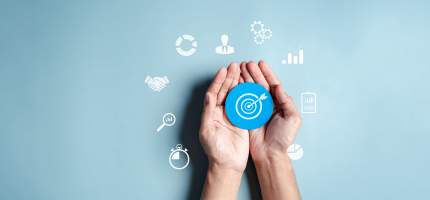 Eine Zielscheibe aus Papier liegt in offenen Handflächen.