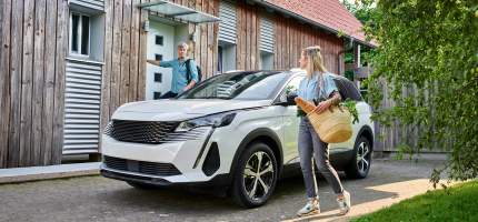 Mann und Frau steigen aus dem Auto vor ihrem Haus.