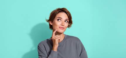 Junge Frau schaut nachdenklich hoch.
