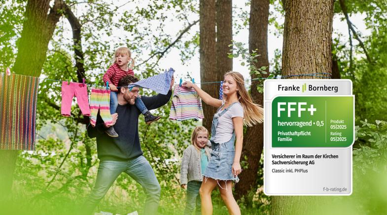Eine lachende junge Familie hängt Wäsche auf eine Leine zwischen zwei Bäumen.