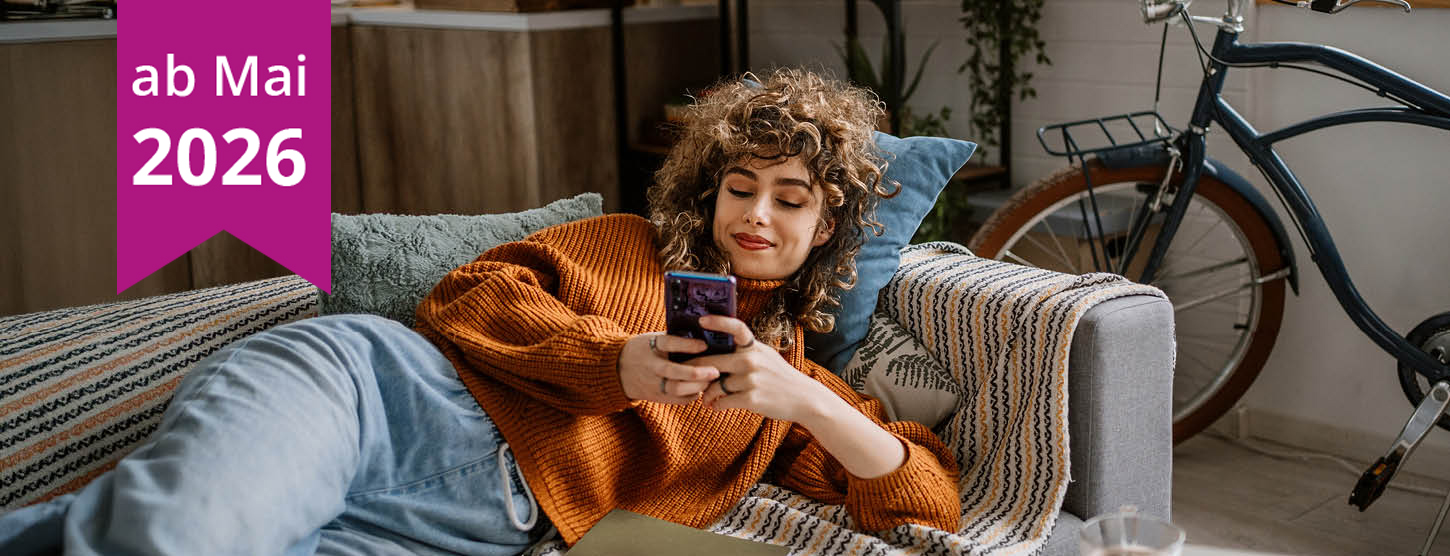 Eine junge Frau schaut entspannt auf ihr Smartphone.