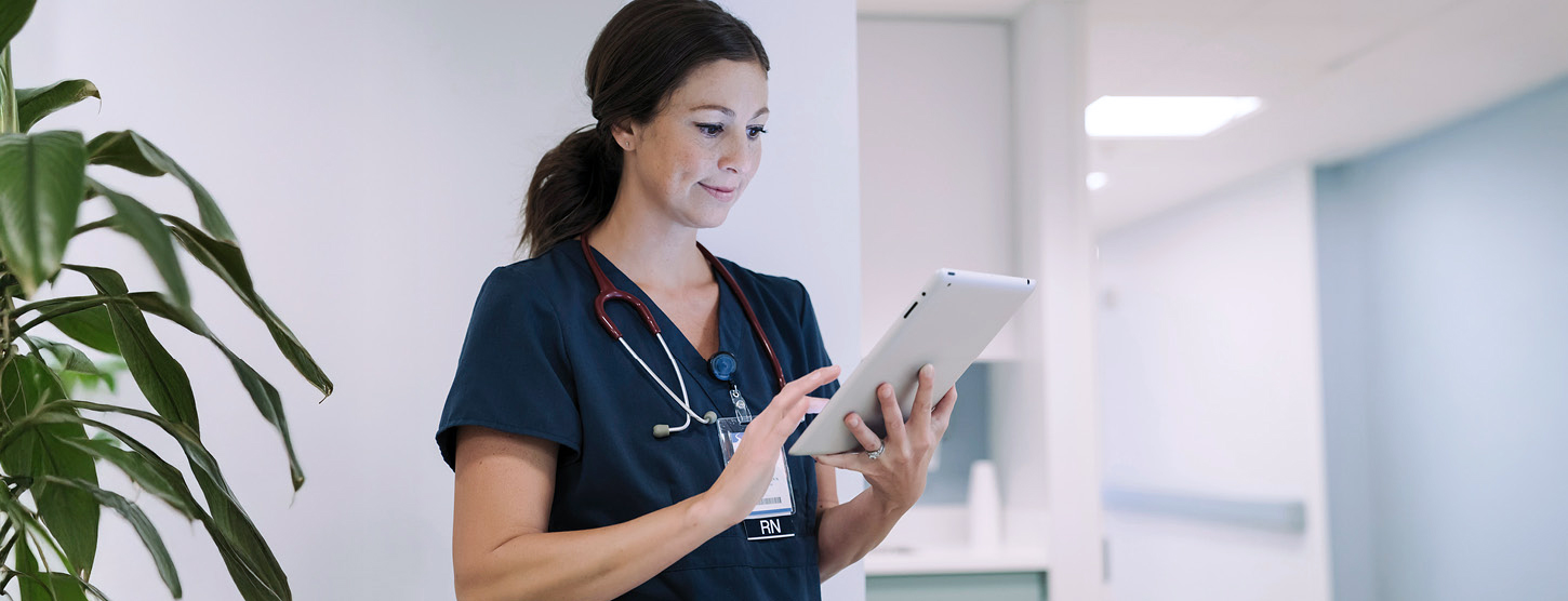 Junge Ärztin schaut im Krankenhaus auf ein Tablet.