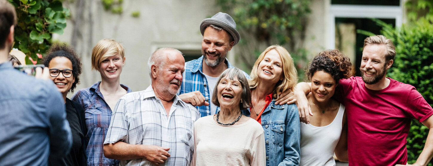Personen machen ein Gruppenfoto und lächeln.