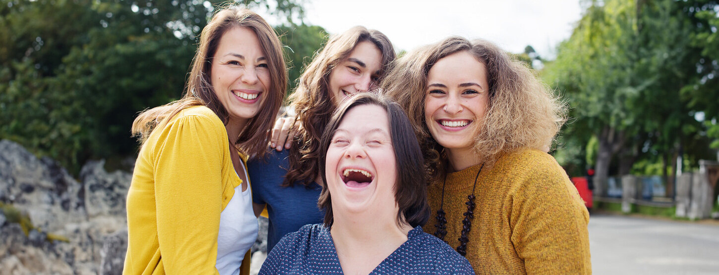 Vier Frauen lachen in die Kamera.