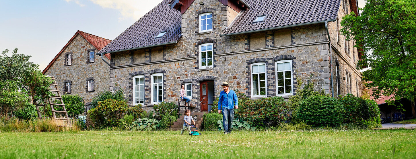 Vater spielt mit seinem Kind im Garten.