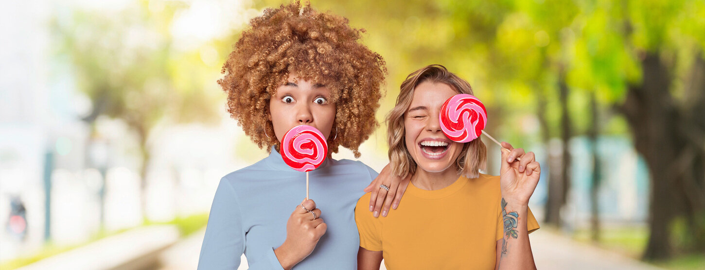 Zwei Junge Frauen mit pinken Lollis.