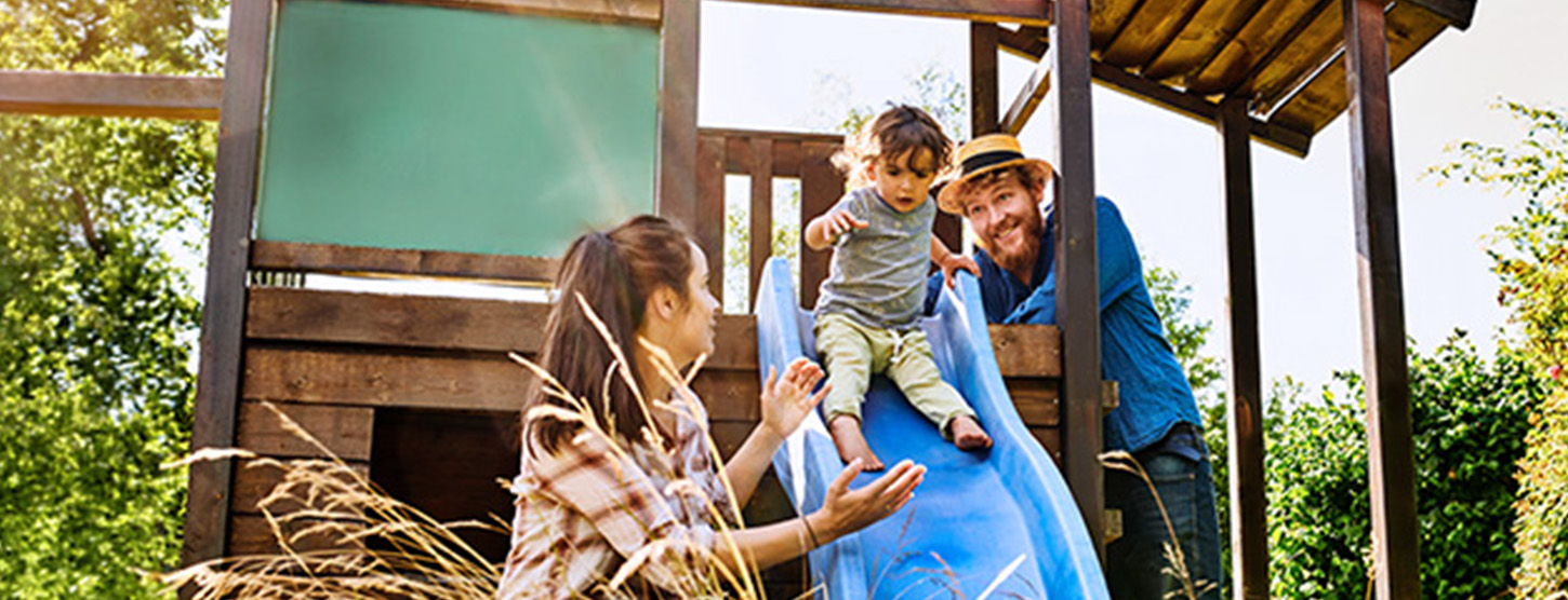 Eine Familie mit einem kleinen Kind auf einer Rutsche.