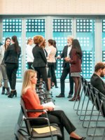 Viele Menschen befinden sich in einem Konferenzraum.