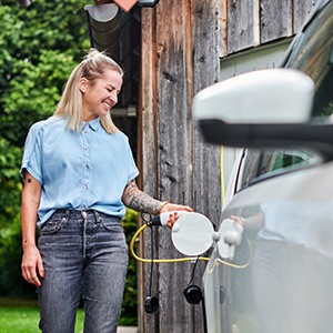 Eine Frau lädt Ihr E-Auto.