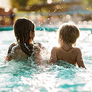 Kinder schwimmen in einem Gartenpool.