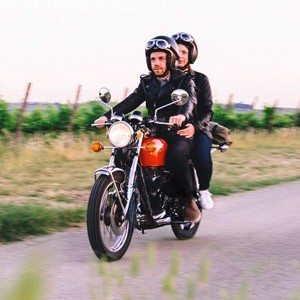 Ein junges Paar fährt auf einem Kleinkraftrad