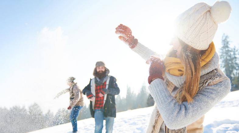 Junges Paar bei Schneeballschlacht.
