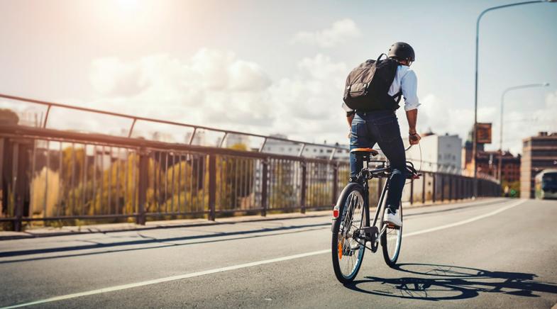 Ein Mann mit Rucksack fährt Fahrrad.