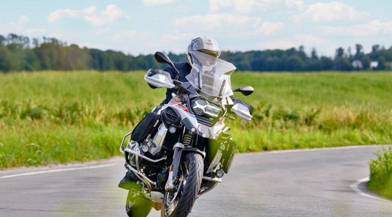 Ein Motorradfahrer auf einer Landstraße fährt um eine Kurve.