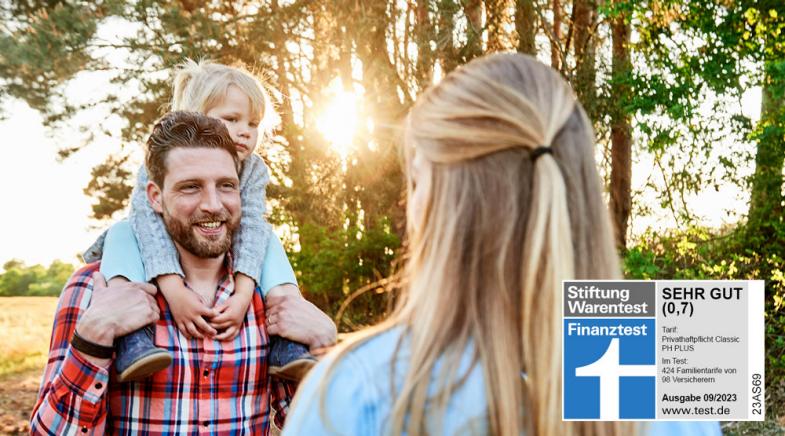 Eine Familie steht vor Bäumen und einem Feld.