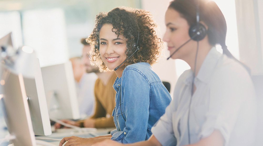 Zwei Frauen mit Headset im Büro.