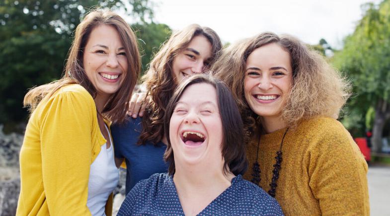 Vier Frauen lachen in die Kamera.