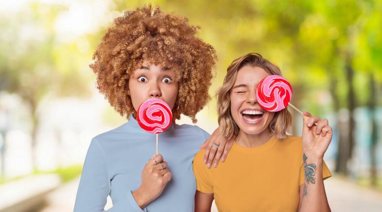 Zwei Junge Frauen mit pinken Lollis.