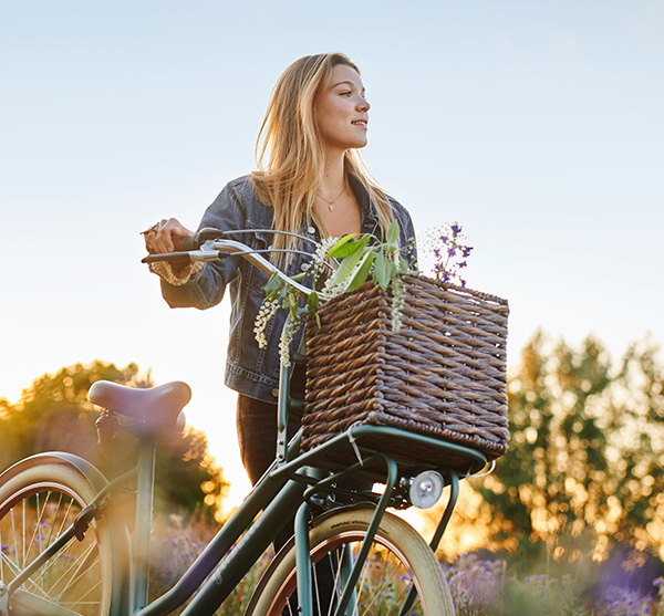 Eine junge Frau schiebt ihr Fahrrad.