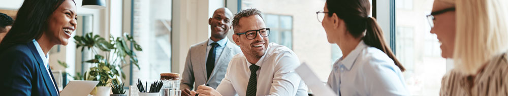 Diverse businesspeople laughing during a meeting around an offic