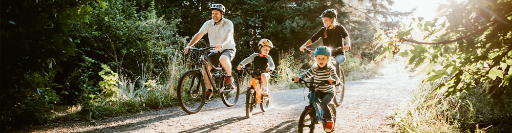 Eine Familie fährt mit ihren Fahrrädern durch einen Wald