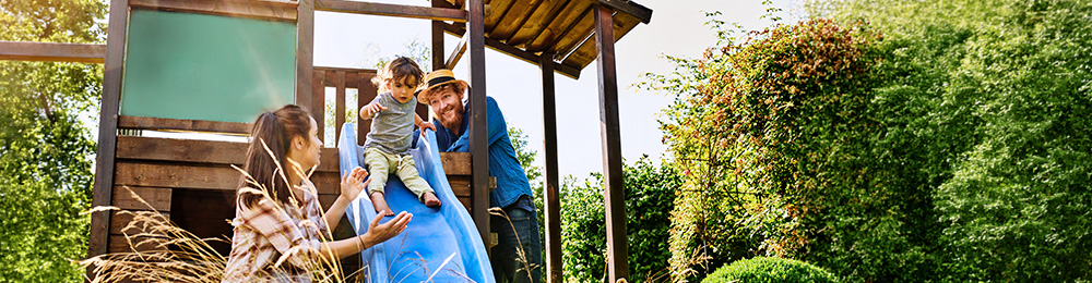 Eine Familie mit einem kleinen Kind auf einer Rutsche.